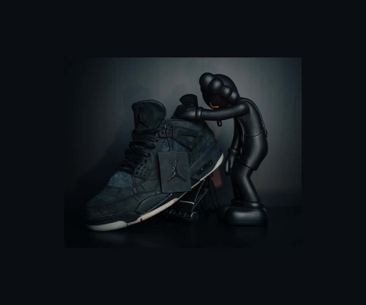 Kaws X Air Jordan 桌布 壁紙 — 一個亮面黑色KAWS公仔溫柔地擁抱一雙深灰色Jordan波鞋，背景是充滿氣氛的漸變色。