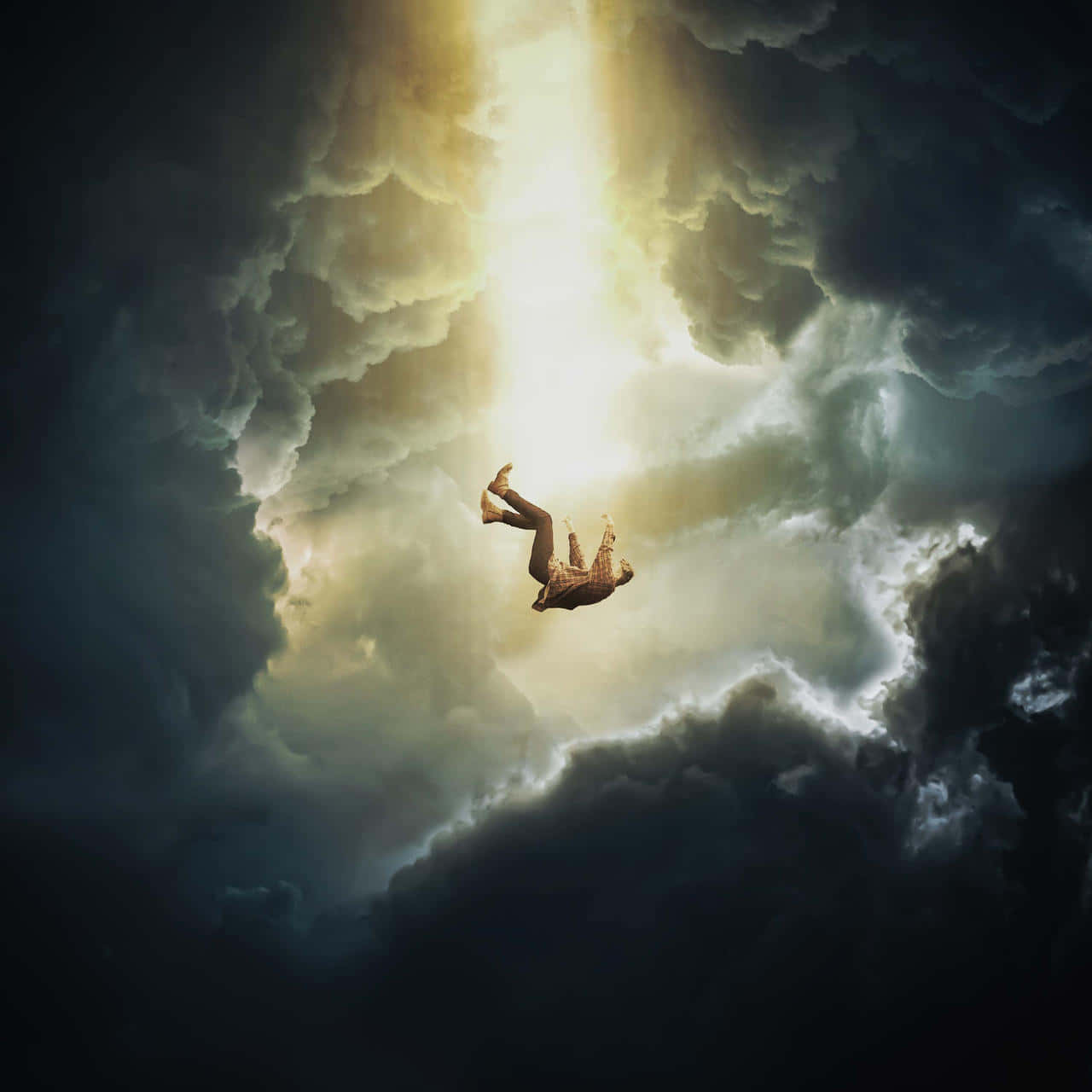 grace 桌布 壁紙 — 一個人倒轉漂浮穿過黑暗暴風雲，朝向從上方穿透而來的燦爛金色光芒。