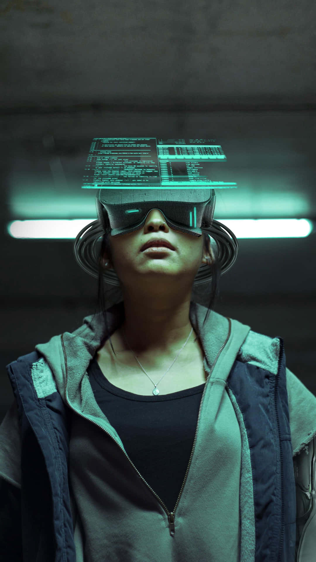 virtual reality 桌布 壁紙 — 一個人在昏暗的工業空間中佩戴未來感VR眼鏡，眼睛上方懸浮著發光的綠色數據流。