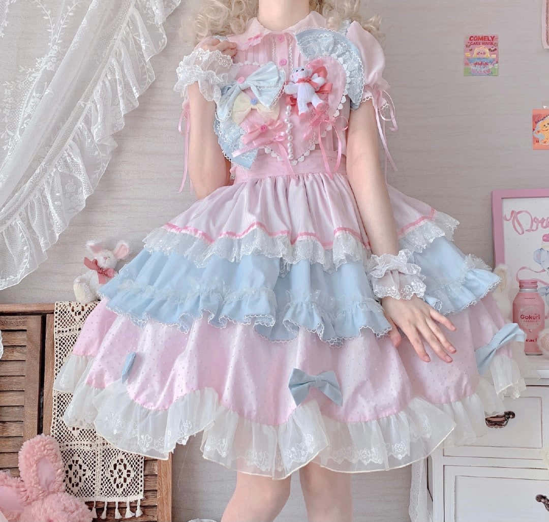 Lolita Fashion 桌布 壁紙 — 一個人在舒適的房間裡穿著粉紅色和藍色的洛麗塔連衣裙，帶有荷葉邊、蕾絲、蝴蝶結和毛絨玩具。