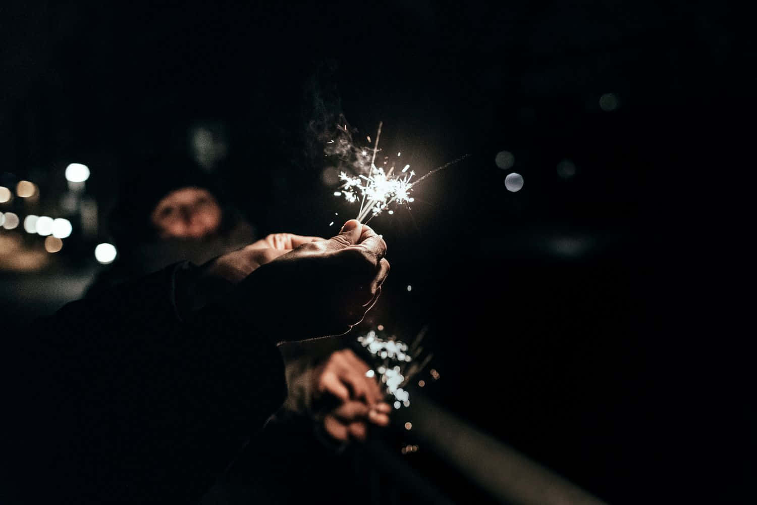 一個人在黑暗中手持煙花棒 壁紙