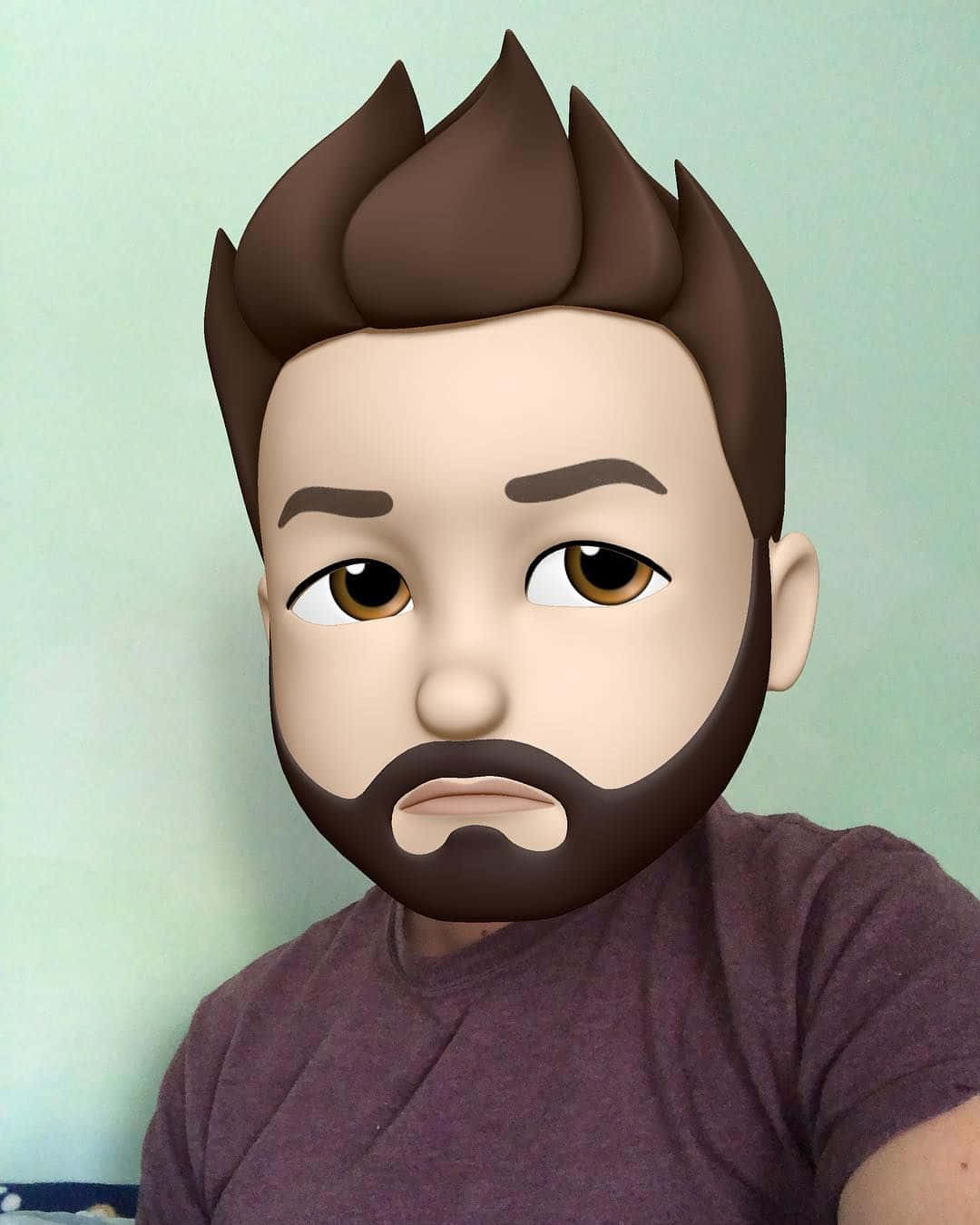 Animojis 桌布 壁紙 — 一個人戴著卡通表情符號面具，面具上有刺刺的棕色頭髮和鬍鬚，穿著紫色襯衫。