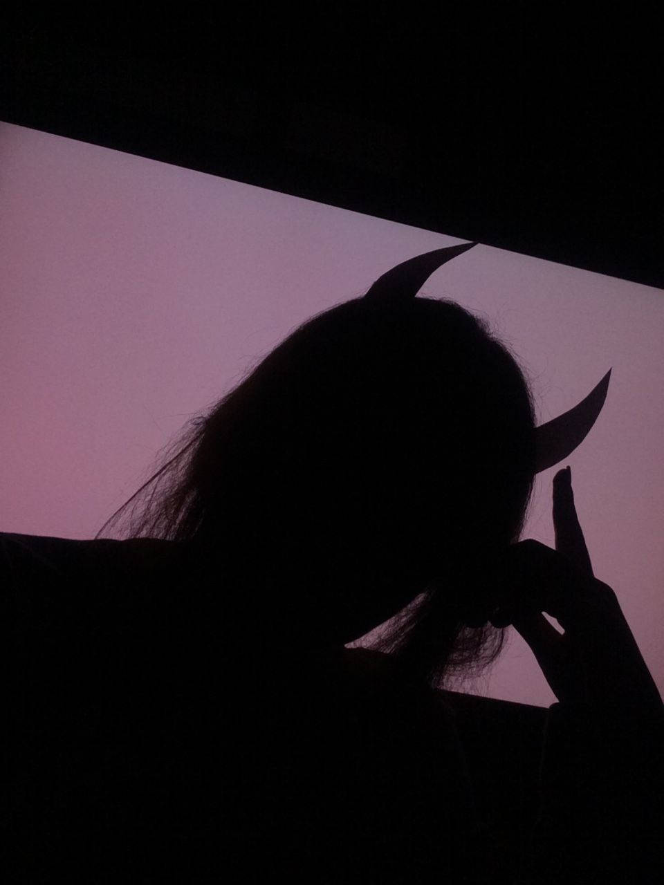 Devil Horns 桌布 壁紙 — 一個人戴著惡魔角，在柔和的紫色暮色天空下做出和平手勢的剪影。