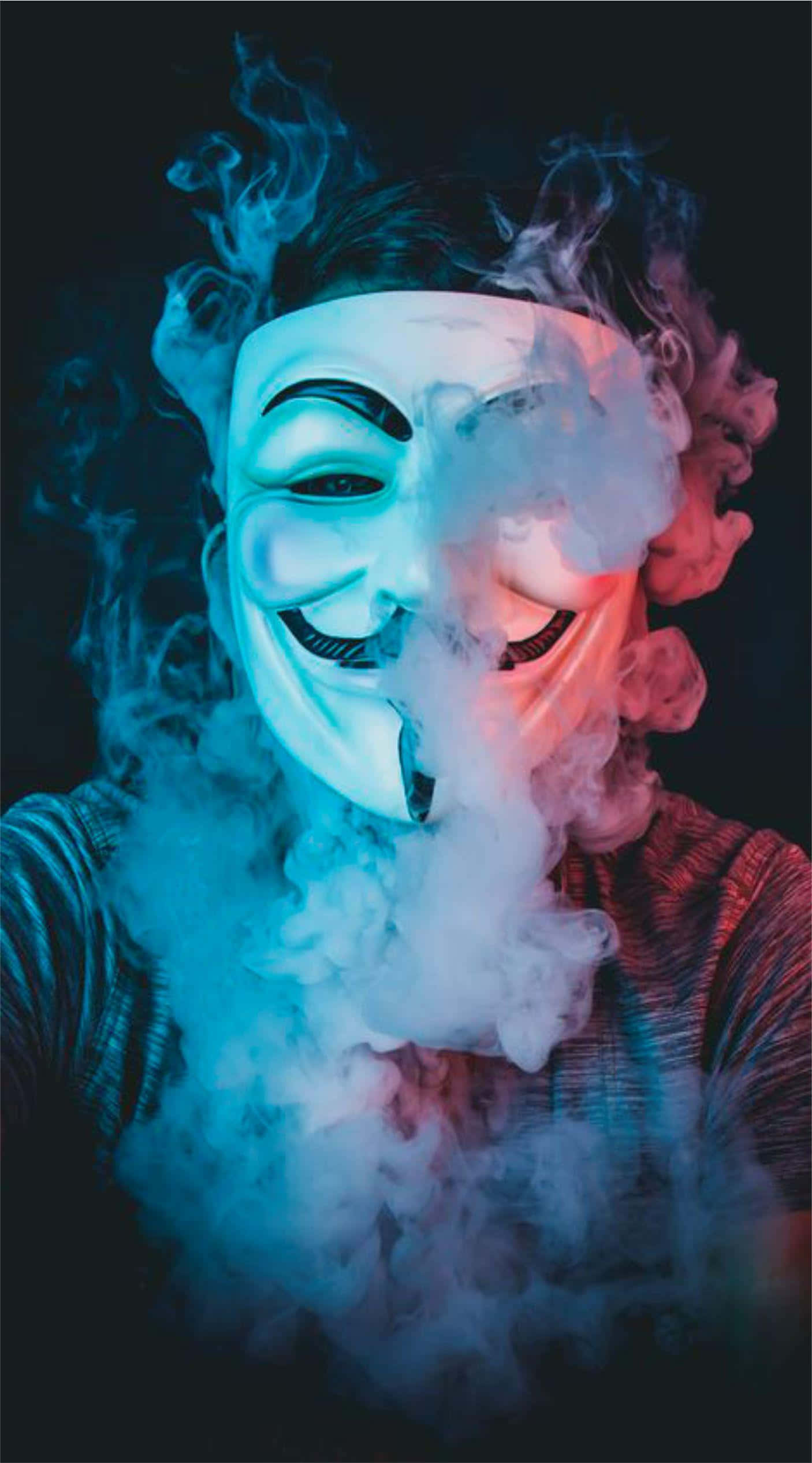 Anonymous 桌布 壁紙 — 一個人戴著白色蓋伊·福克斯面具，在黑暗背景下呼出旋轉的藍色和紅色煙霧。