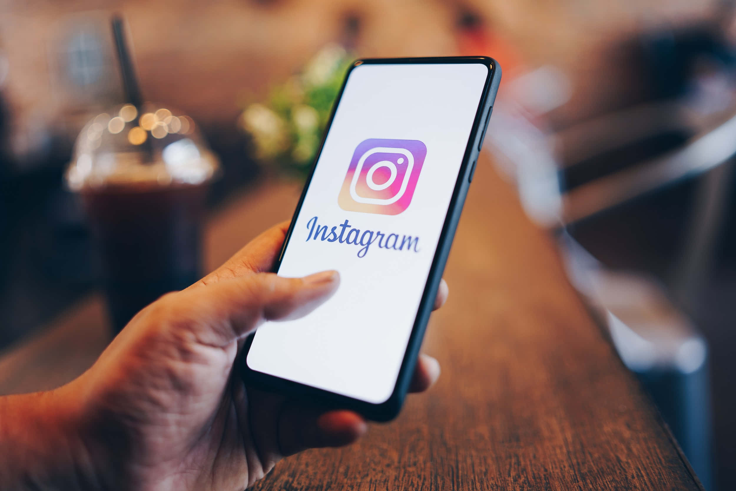 一個人手持印有Instagram標誌的手機 壁紙