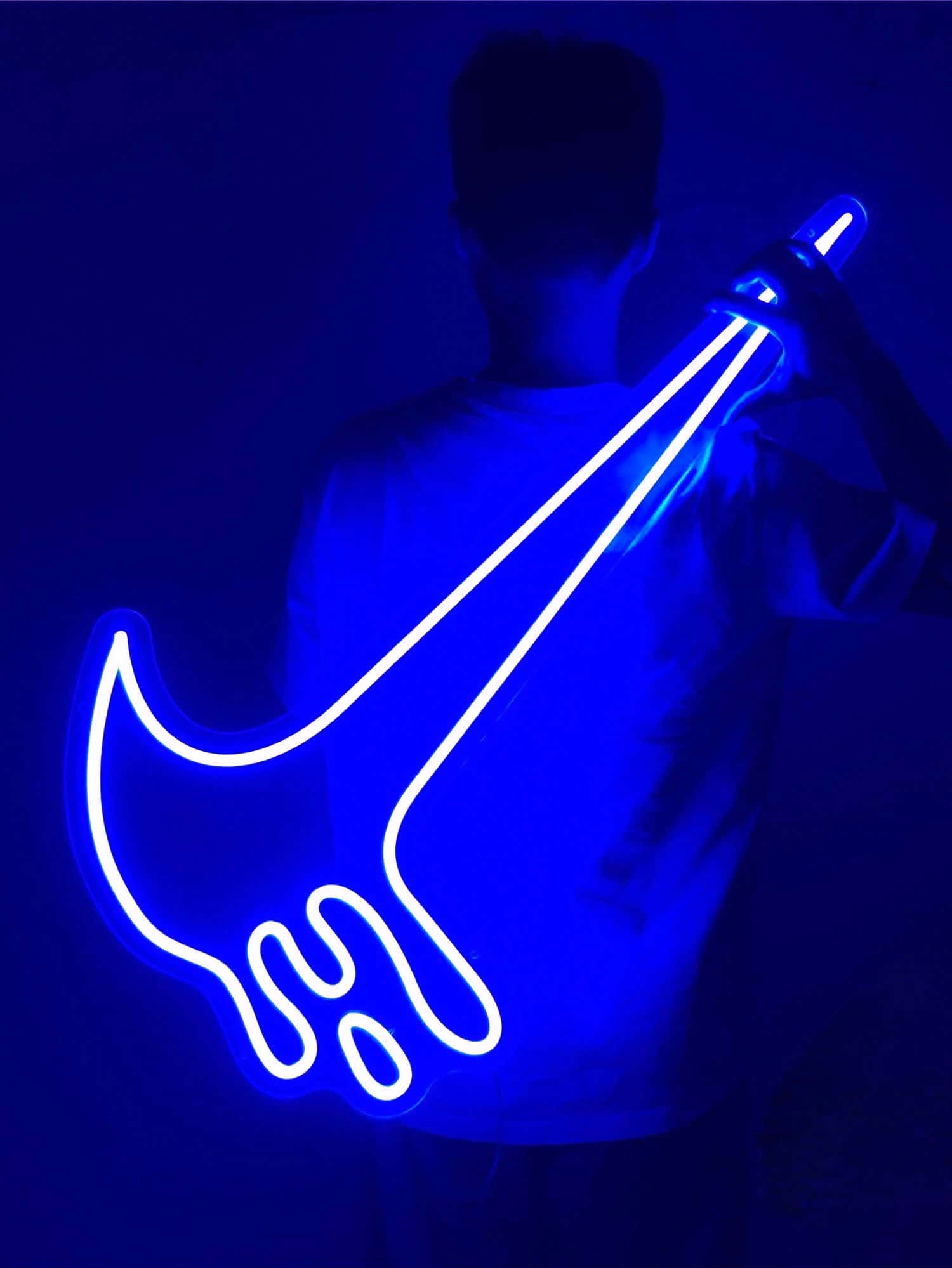 Blue Nike 桌布 壁紙 — 一個人手持發光藍色霓虹結他輪廓，背景黑暗，散發出充滿活力的電光藍色光芒。