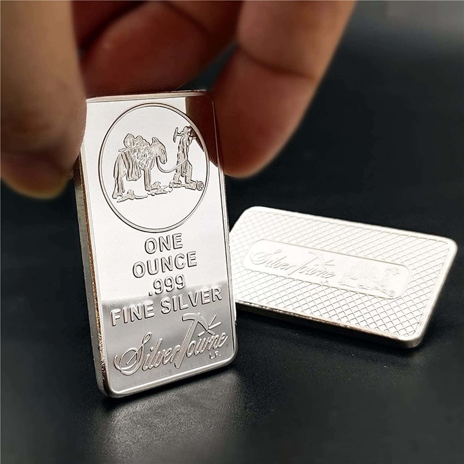 一個人手持銀條，旁邊有一個小盒子 壁紙