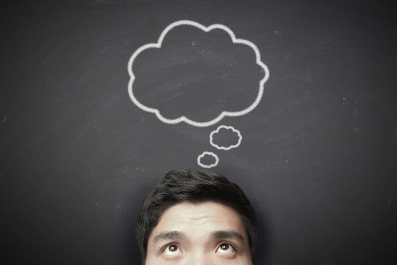 Thinking 桌布 壁紙 — 一個人抬頭望向深色黑板上一幅用粉筆畫的思考泡泡，暗示沉思。