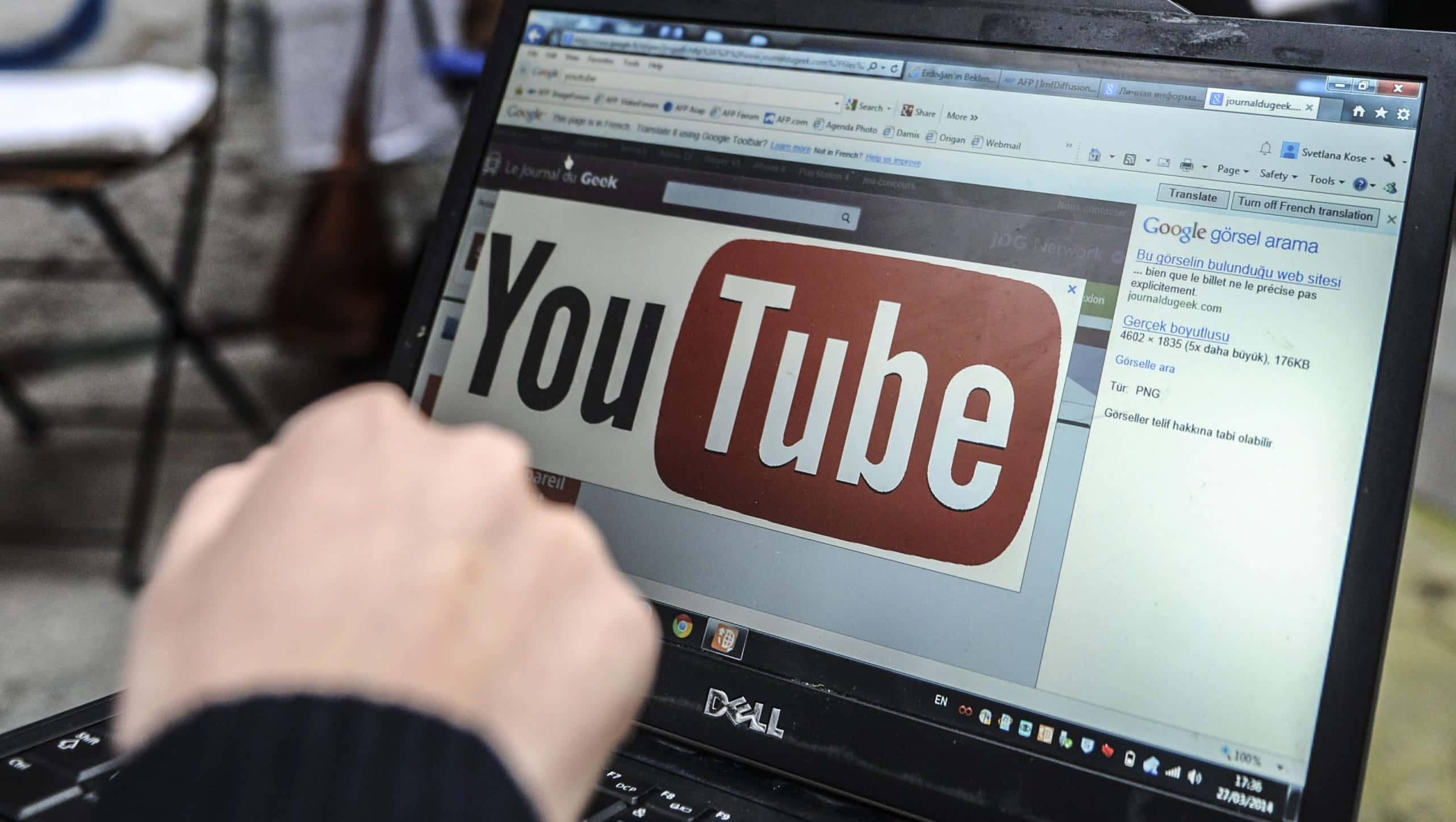 一個人正在使用一部帶有YouTube標誌的手提電腦 壁紙