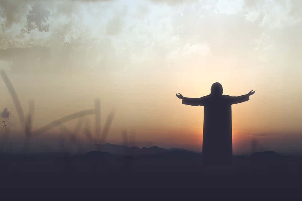 Gospel 桌布 壁紙 — 一個人物在遠山之上張開雙臂，映襯著燦爛的日落天空的剪影。