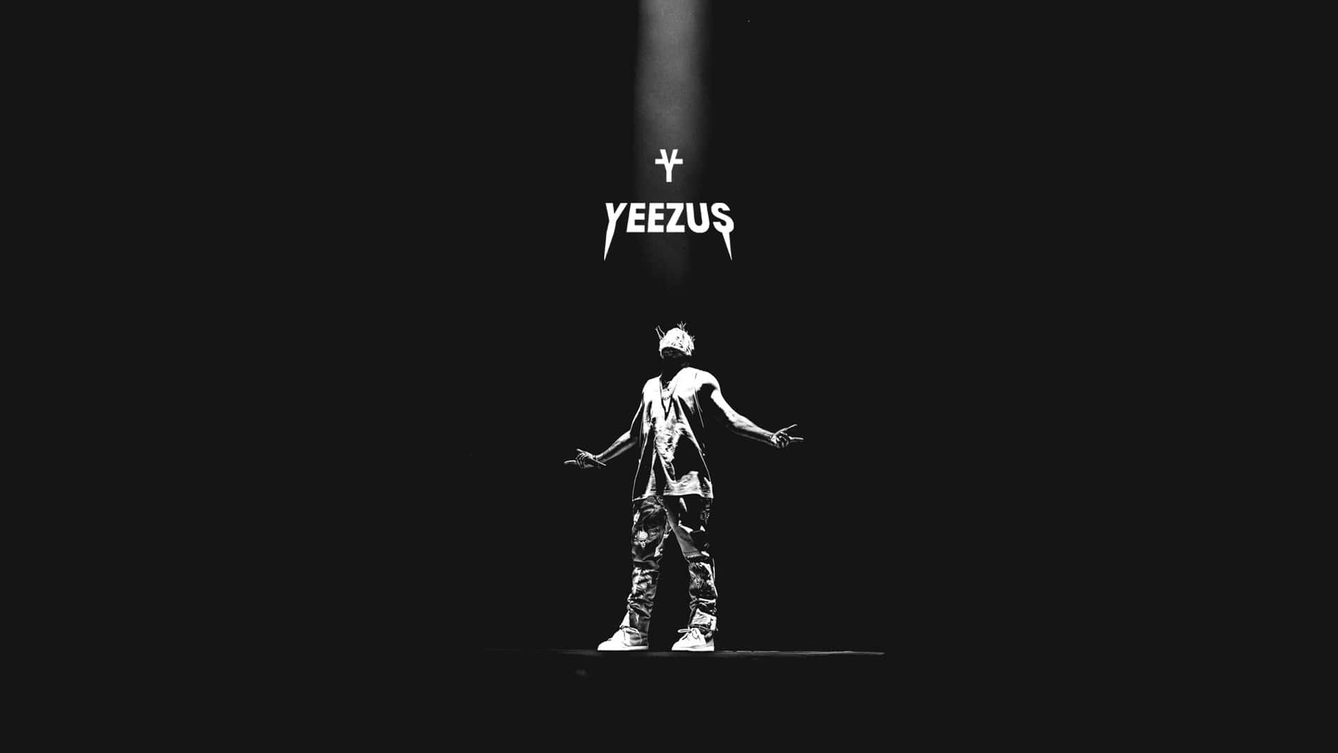 Kanye 桌布 壁紙 — 一個人獨自站在黑暗舞台上的聚光燈下，上方有 'YEEZUS' 文字，強烈的黑白對比。
