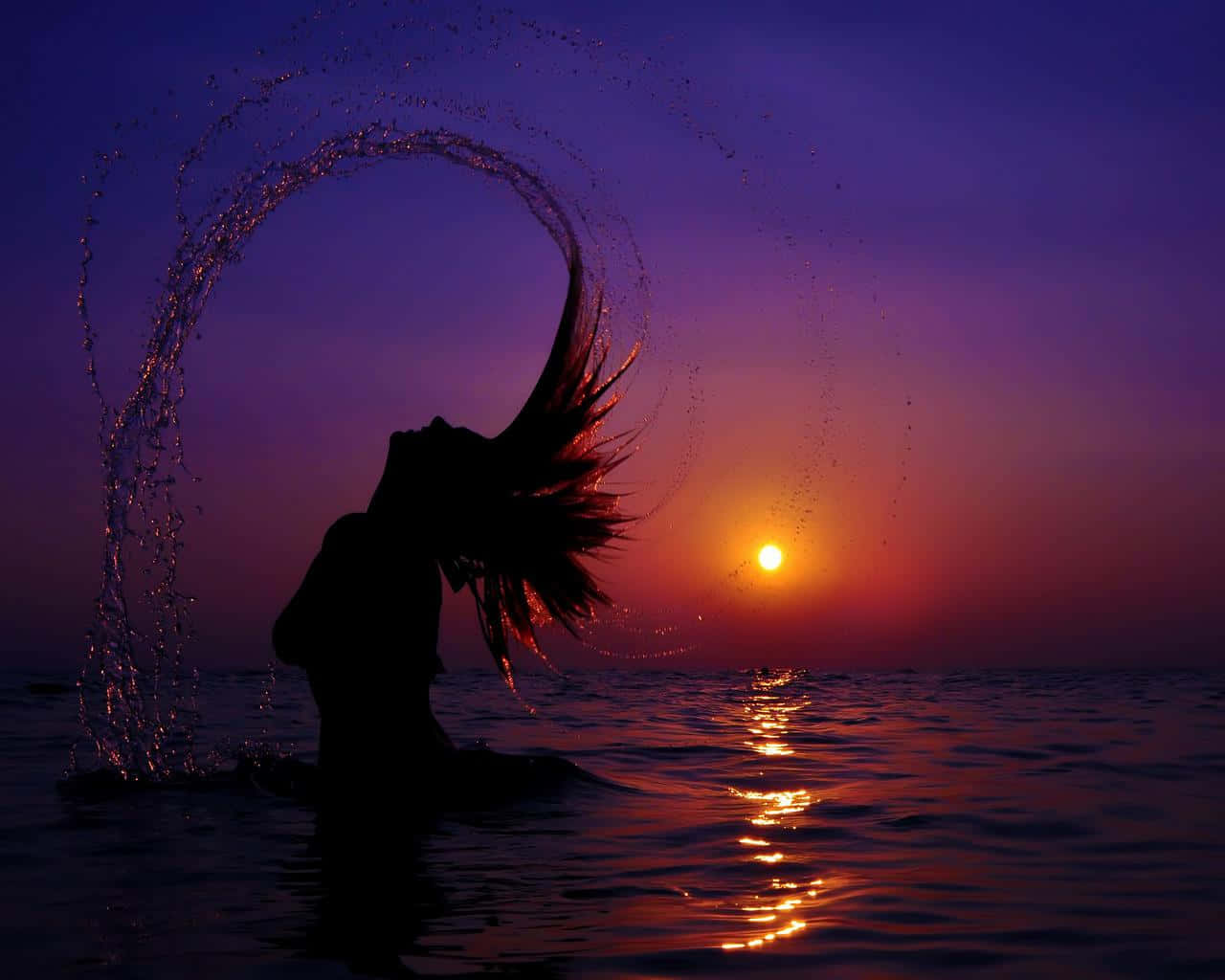 Sunset Silhouette 桌布 壁紙 — 一個人的剪影，在海洋上充滿活力的紫色和橙色日落背景下，優雅地拋出水弧。