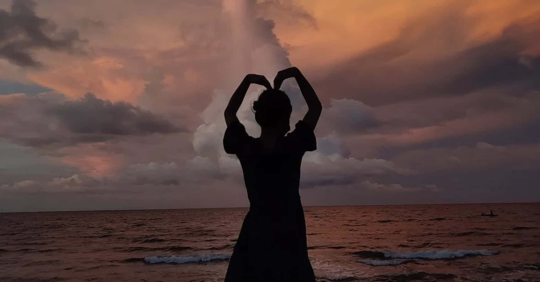 Heart Silhouette 桌布 壁紙 — 一個人的剪影，雙手比出心形，背景是海洋上戲劇性的日落。