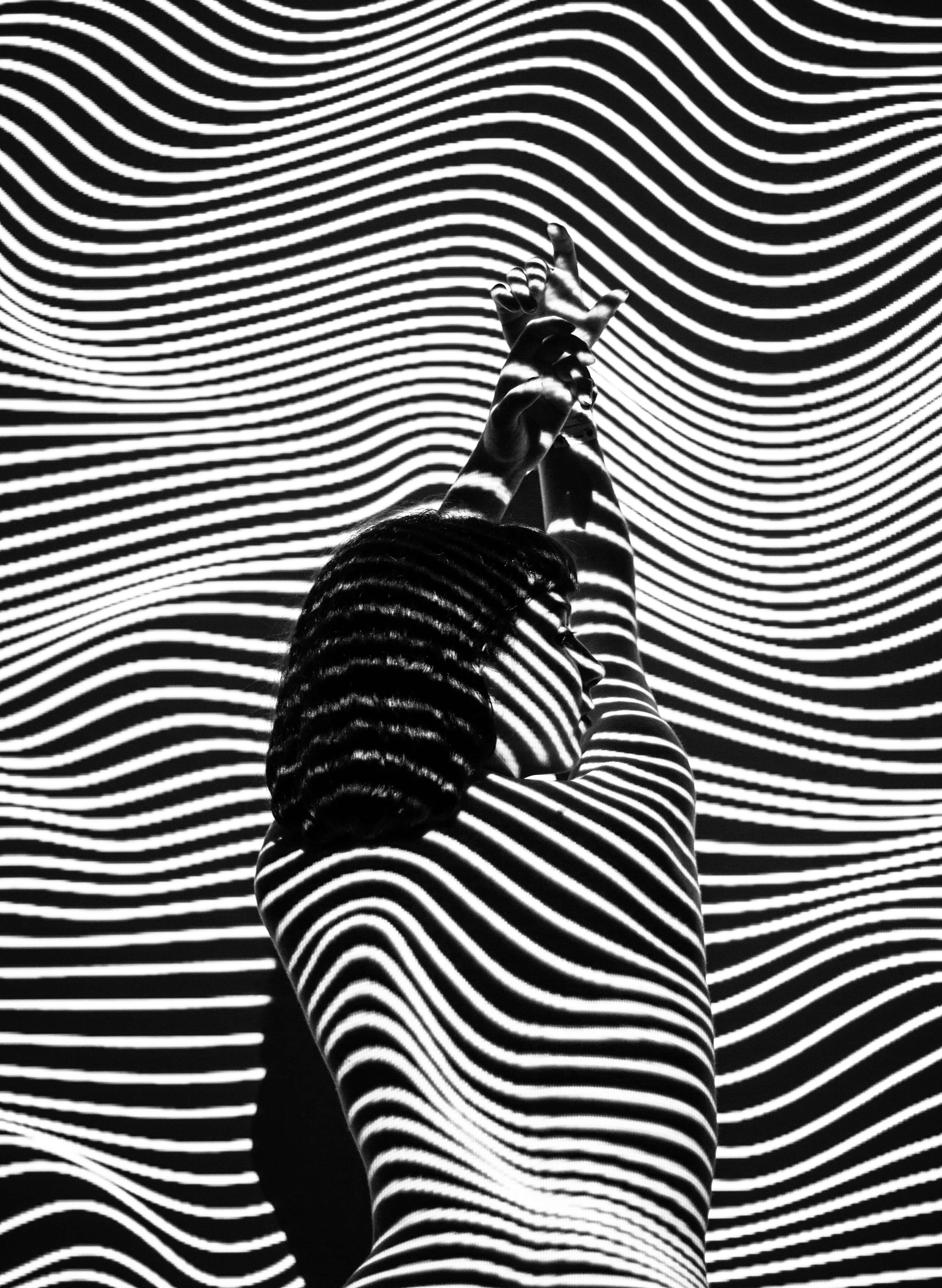 Black And White Abstract Art 桌布 壁紙 — 一個人的黑白剪影，雙臂高舉，背景是催眠般的波浪條紋。