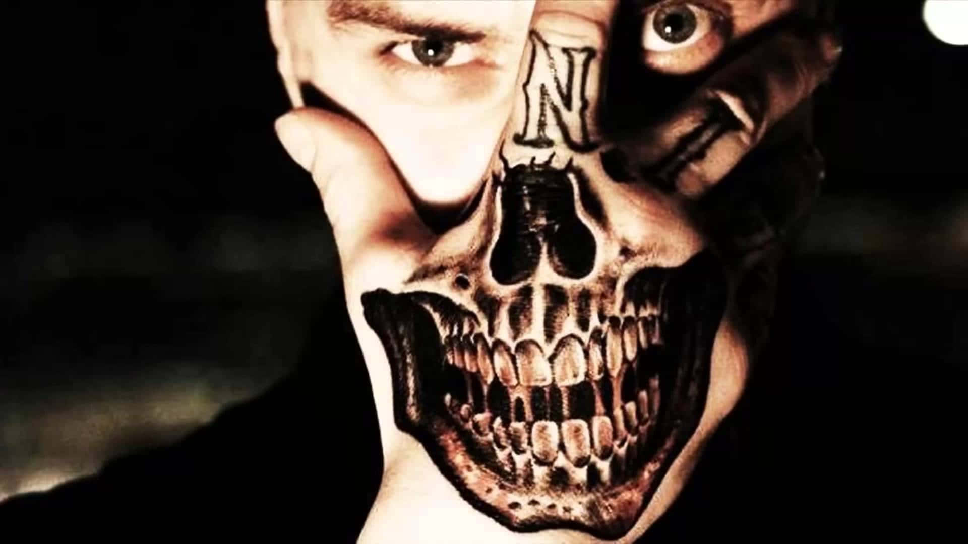 Halloween Tattoos 桌布 壁紙 — 一個人舉起一隻手，手掌和手指上覆蓋著精細的骷髏紋身，在黑暗背景下露出一隻眼睛和部分臉龐。