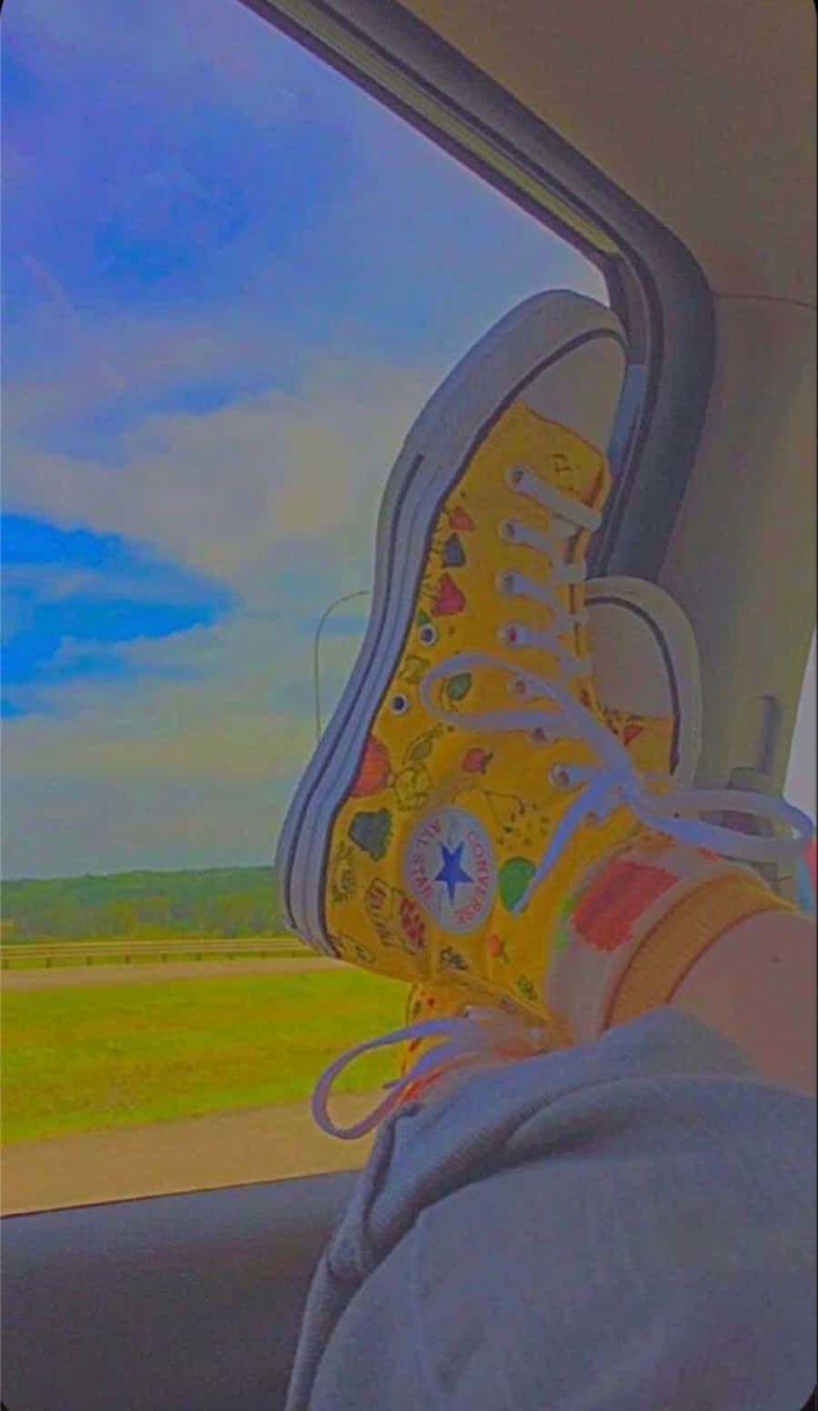 一個人雙腳穿著黃色Converse鞋坐在車內 壁紙