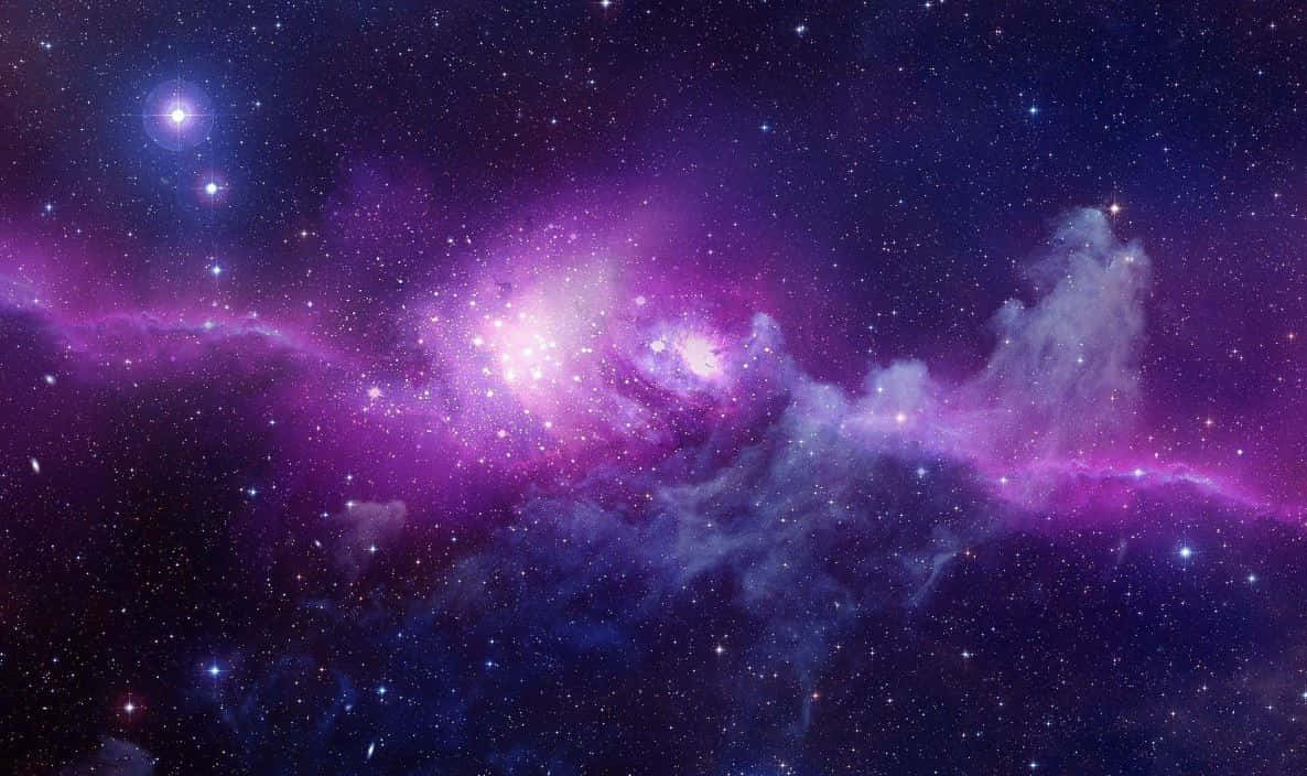 紫色銀河 桌布 壁紙 — 一個令人嘆為觀止的宇宙場景，充滿活力的紫色星雲在繁星點點的深藍色夜空中閃耀。