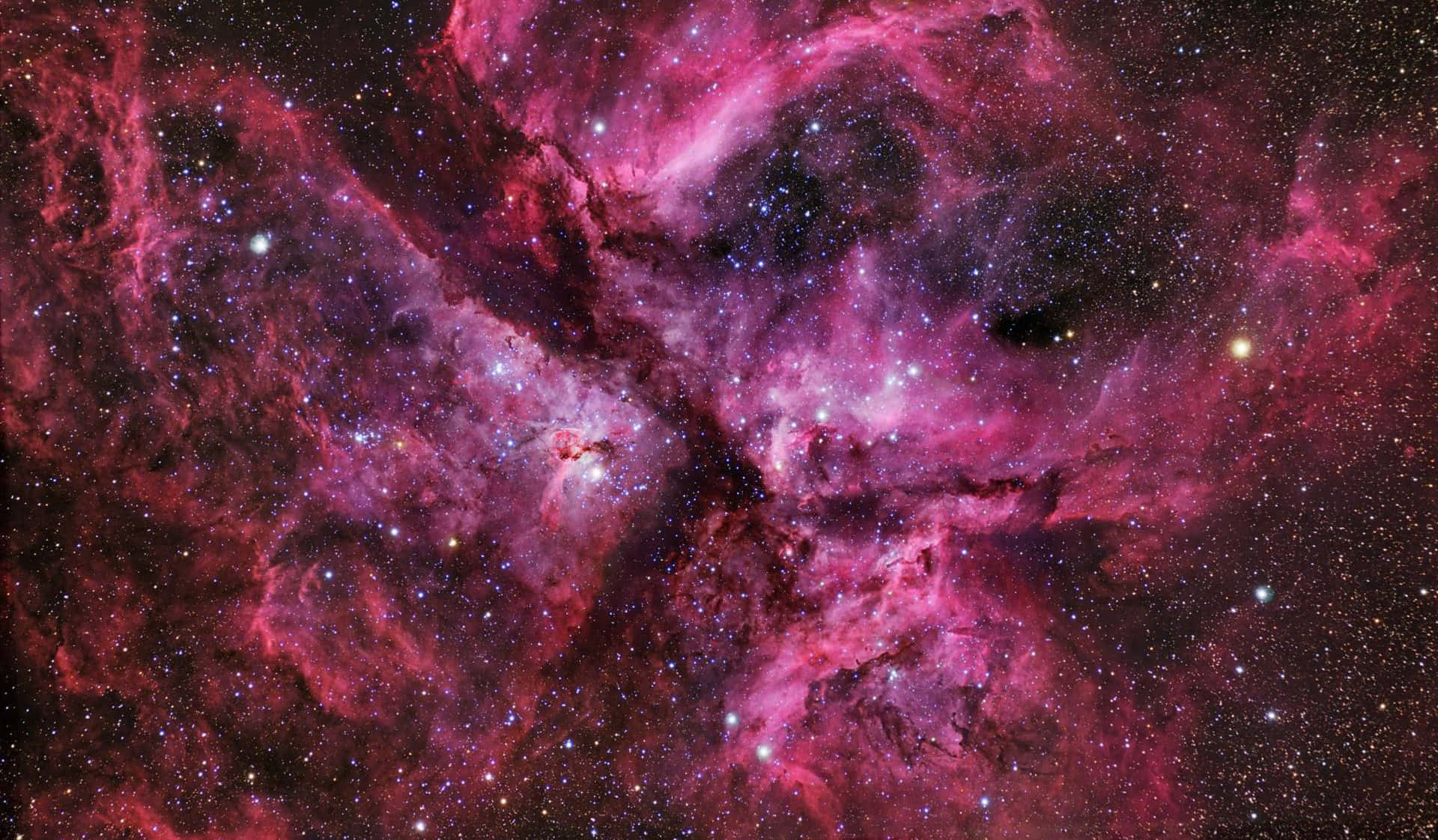 星雲 桌布 壁紙 — 一個令人嘆為觀止的宇宙星雲景觀，在佈滿星辰的黑色虛空中散發著鮮豔的粉紅色和紫色色調。