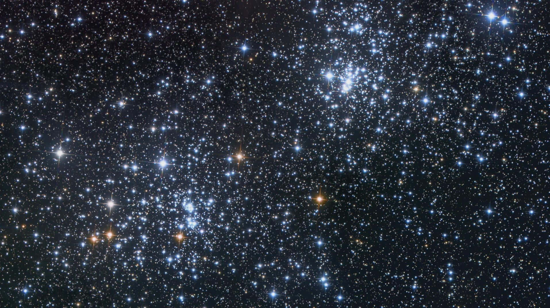 Universe 桌布 壁紙 — 一個令人嘆為觀止的密集星團景象，藍色和橙色的星星在深邃的黑色宇宙虛空中閃耀。