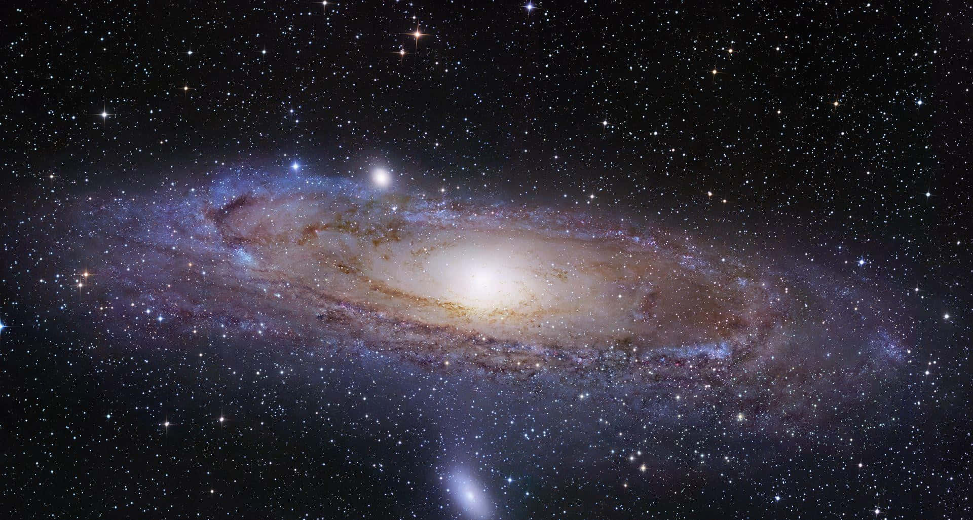 銀河系 桌布 壁紙 — 一個令人嘆為觀止的螺旋星系，在繁星點點的宇宙背景下閃耀著金色和藍色色調。