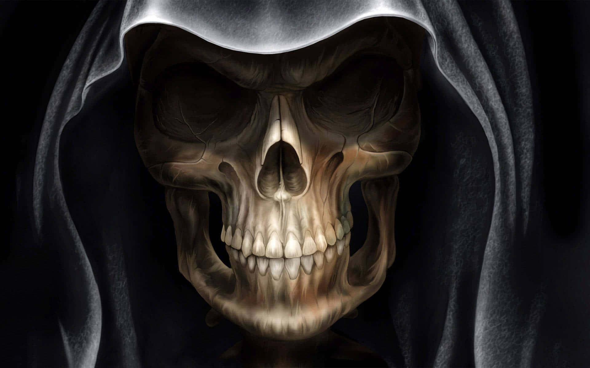 skulls 桌布 壁紙 — 一個令人毛骨悚然的特寫，骷髏臉戴著連帽斗篷，背景陰暗。