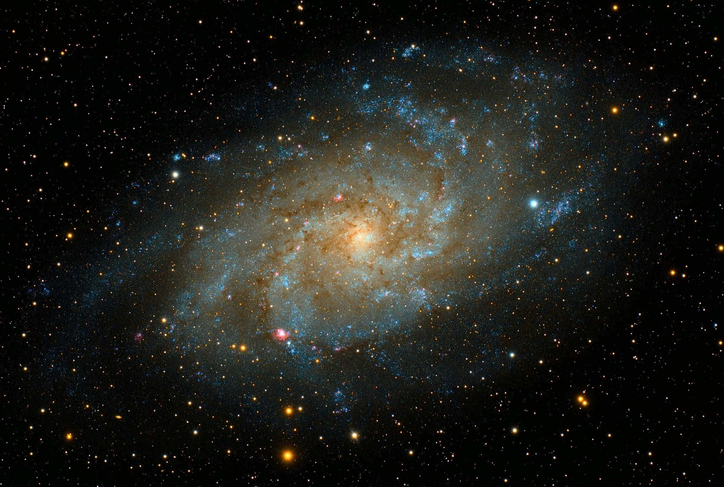 Dark Galaxy 桌布 壁紙 — 一個令人驚嘆的螺旋星系，帶有發光的藍色旋臂和金色核心，被無數遙遠的恆星環繞，背景是深邃的黑色虛空。