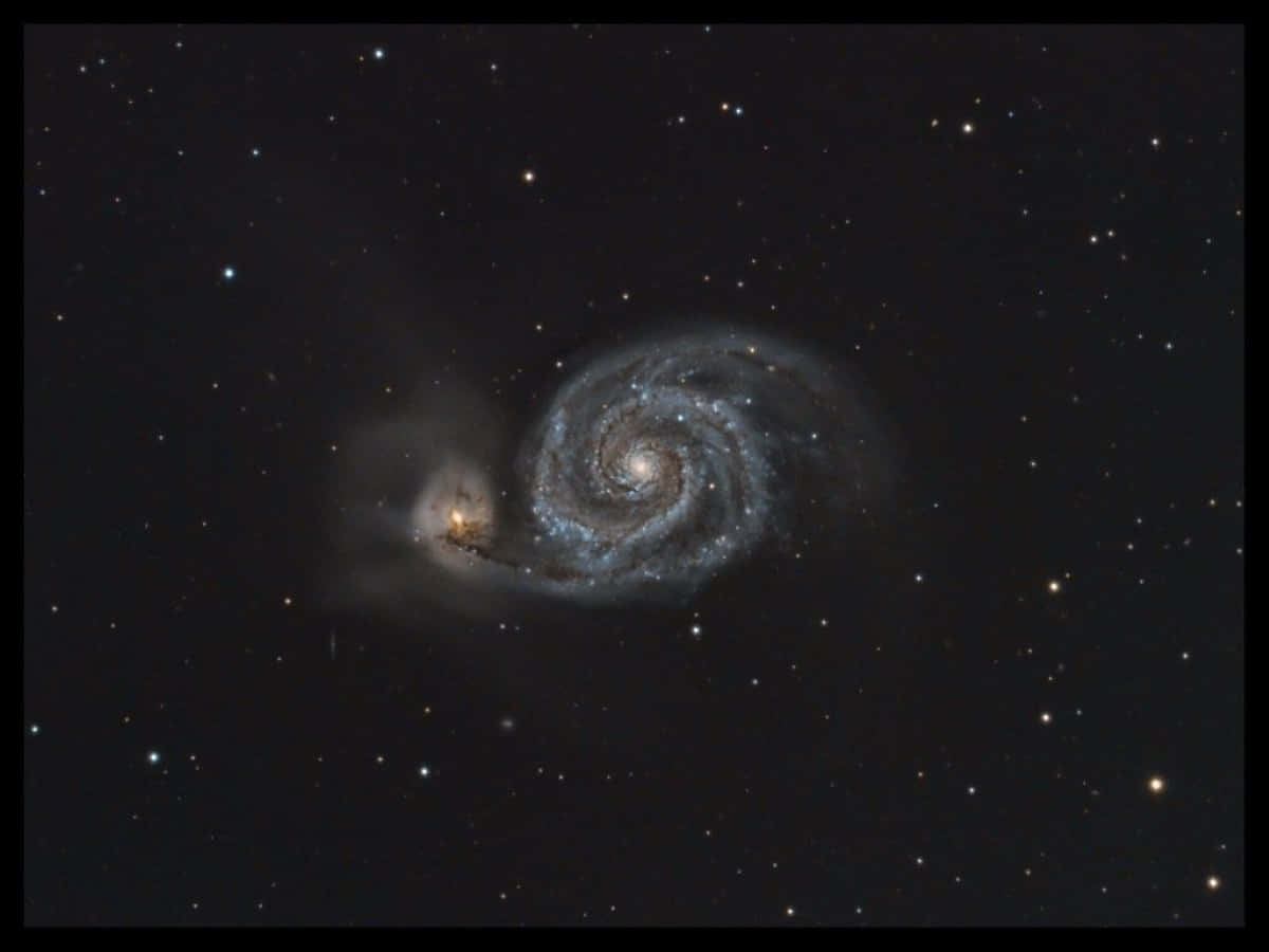 Whirlpool Galaxy 桌布 壁紙 — 一個令人驚嘆的螺旋星系，擁有旋轉的旋臂和明亮的核心，周圍環繞著深空中無數遙遠的恆星。
