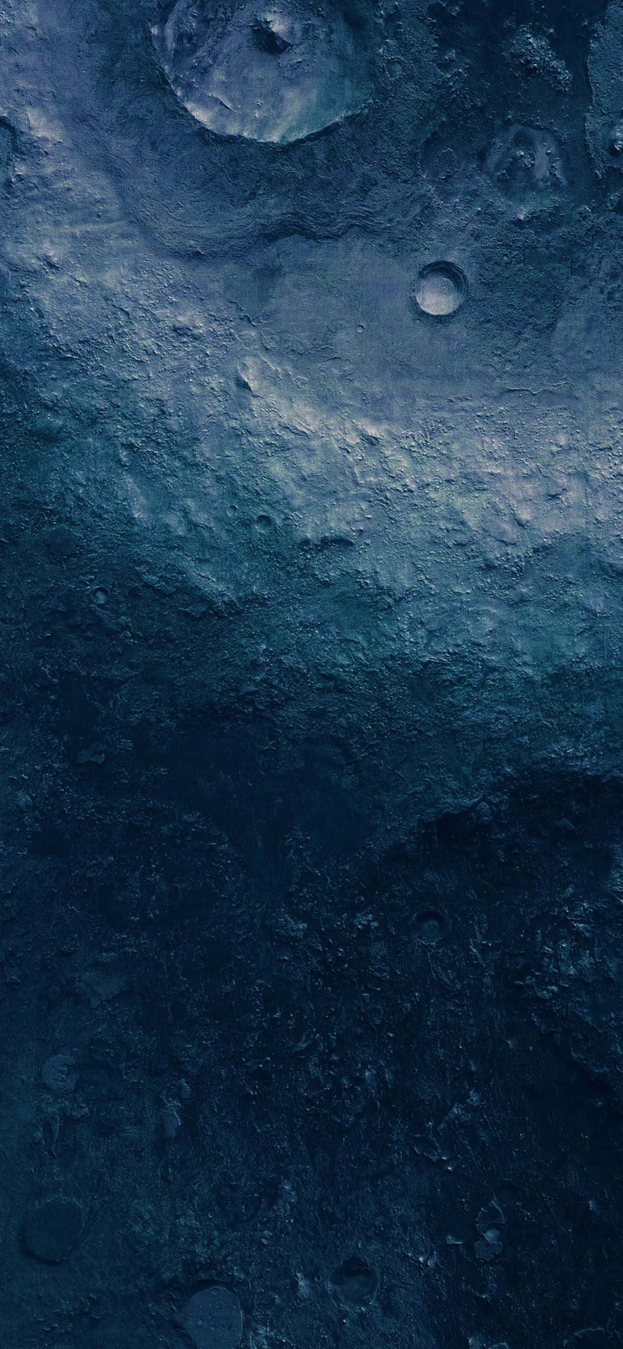 藍色 iPhone 桌布 壁紙 — 一個佈滿隕石坑的月球表面特寫，沐浴在深藍色和灰色調中，帶有微妙的高光。
