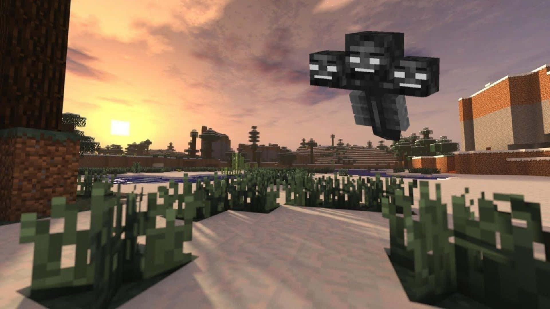 Minecraft Wither 桌布 壁紙 — 一個像素化的 Minecraft 終界使者漂浮在日落時分的雪地地形上，背景有方塊狀的樹木和建築物。