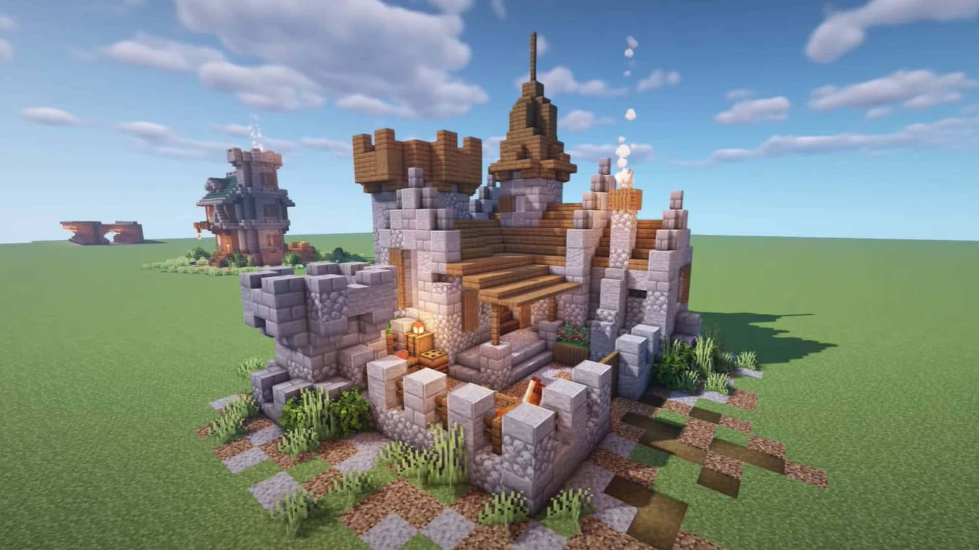 Minecraft Castles 桌布 壁紙 — 一個像素化的Minecraft城堡，有石牆、木樓梯和發光的燈籠，矗立在明亮的藍天下的一片草地上。