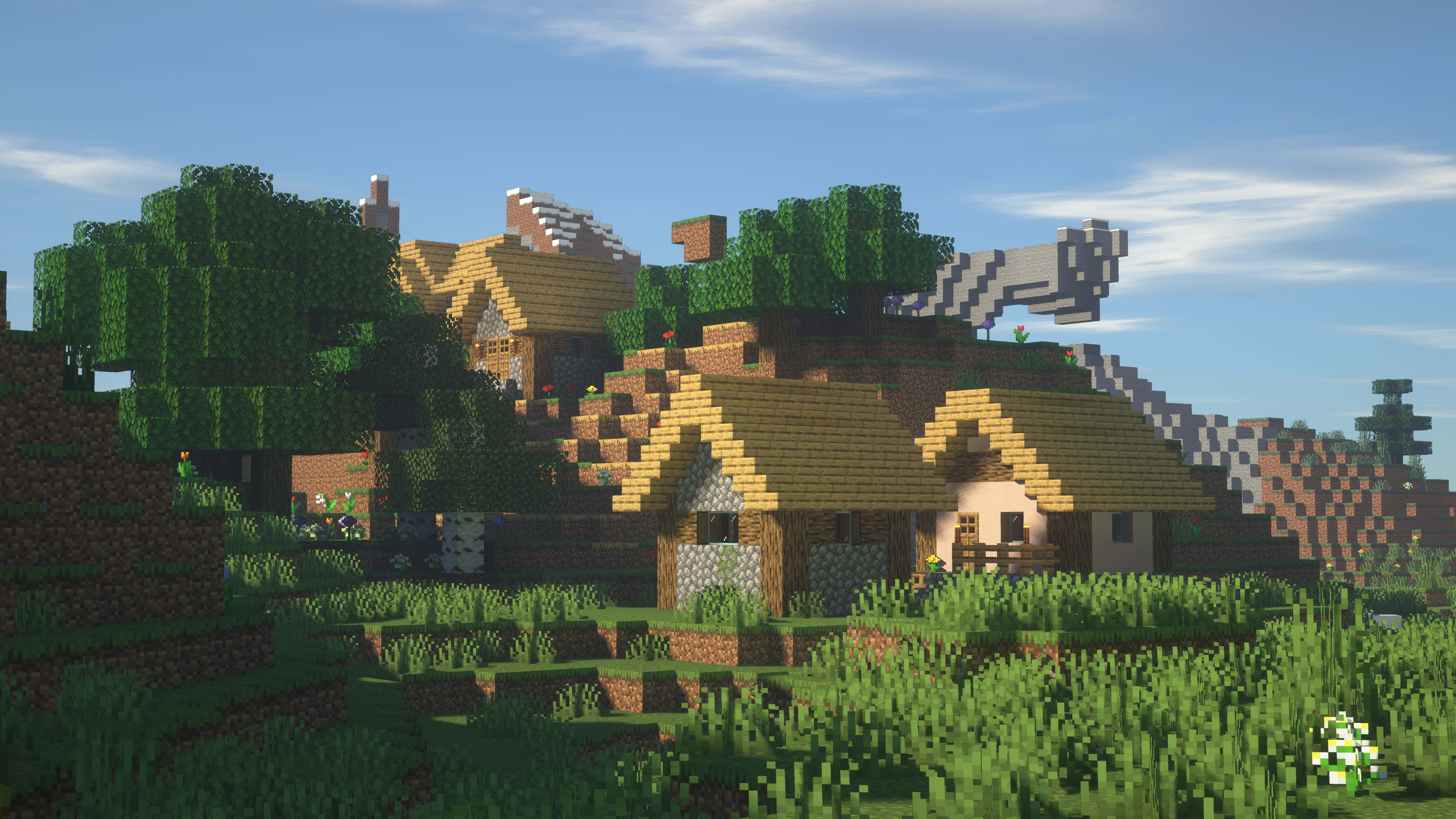 Minecraft Villages 桌布 壁紙 — 一個像素化的Minecraft村莊，有木屋和綠樹，在晴朗的藍天下。