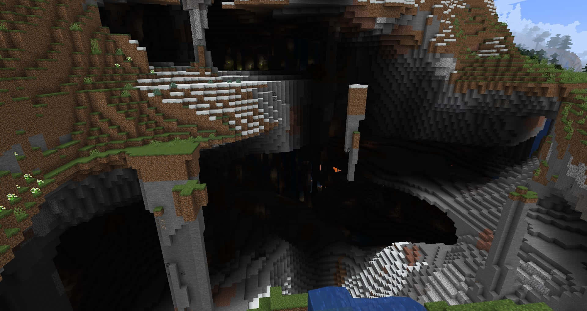 Minecraft Bridges 桌布 壁紙 — 一個像素化的Minecraft洞穴入口，有草坡和石柱，在明亮的天空下。