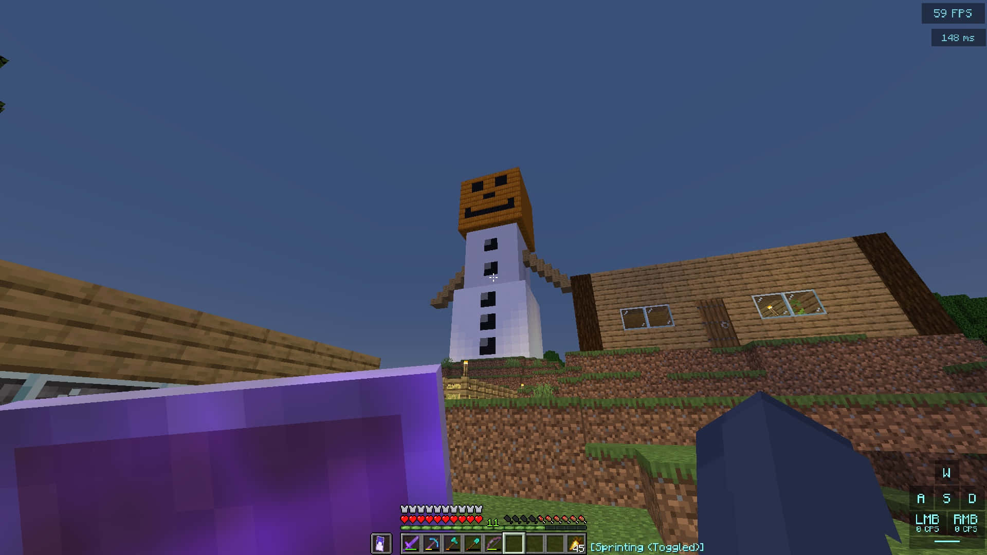 Minecraft Snow Golem 桌布 壁紙 — 一個像素雪人站在Minecraft世界中的木屋旁邊，背景是晴朗的藍天。