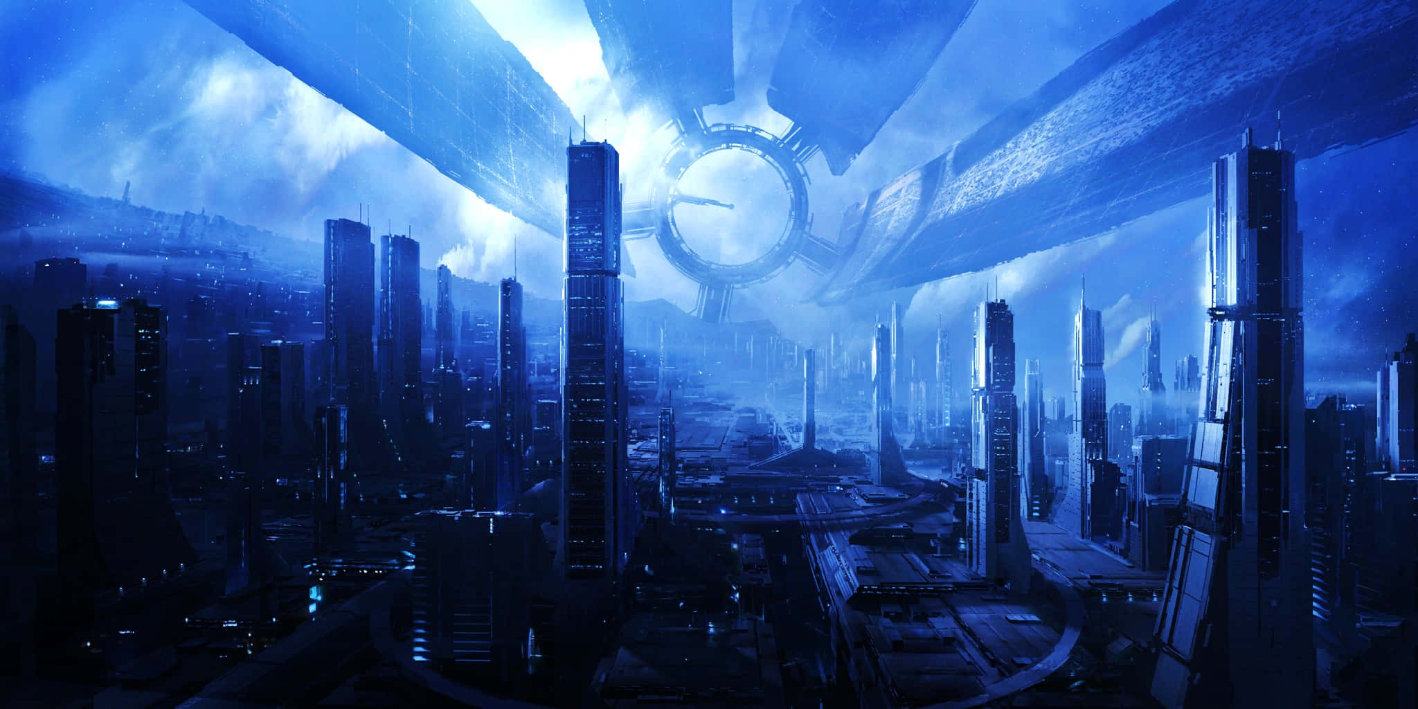 Mass Effect Citadel 桌布 壁紙 — 一個充滿未來感的城市景觀，沐浴在冷藍色光芒中，高聳的摩天大樓和頭頂上巨大的發光環狀結構。