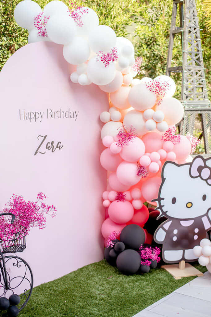 Hello Kitty Party 桌布 壁紙 — 一個充滿歡樂的粉紅色氣球拱門，帶有閃粉和Hello Kitty剪影，裝飾著戶外生日背景。