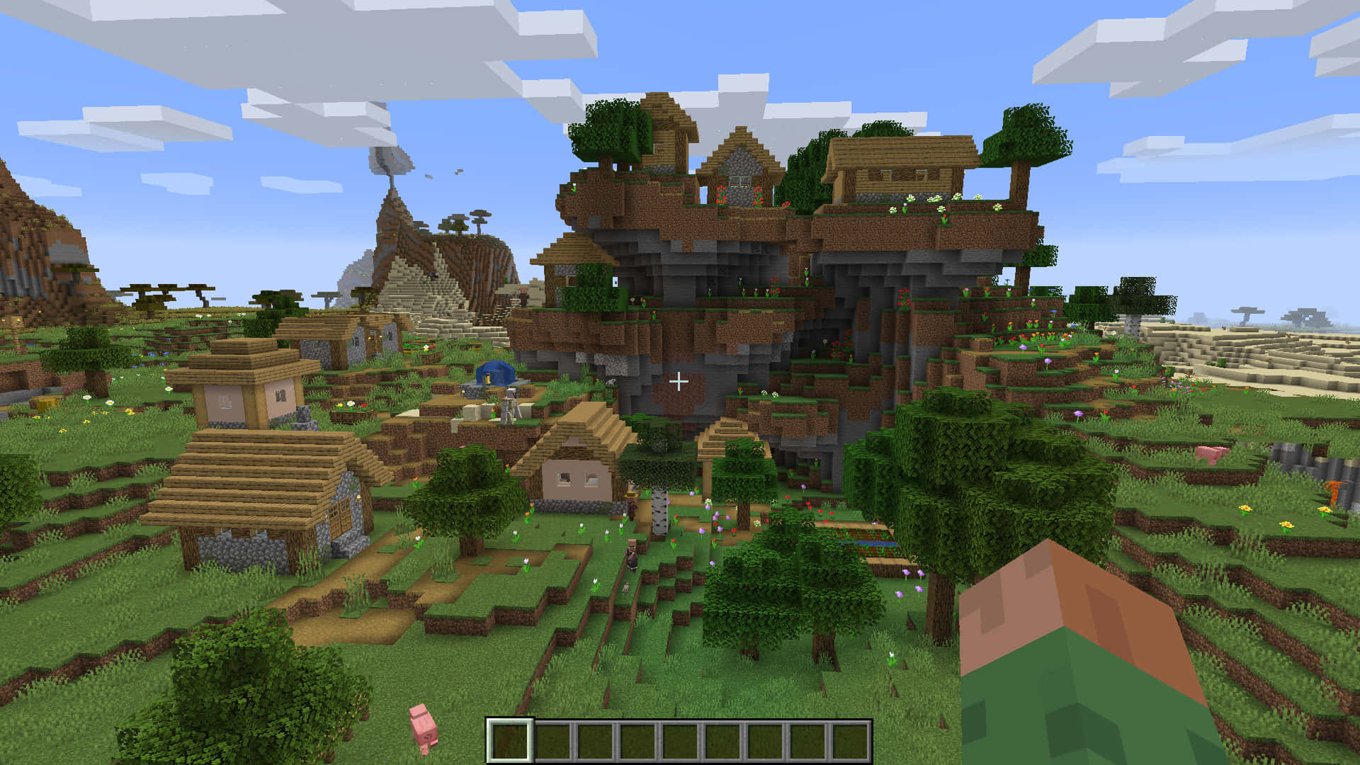 Minecraft Villages 桌布 壁紙 — 一個充滿活力的Minecraft村莊，坐落在長滿青草的山谷中，有木屋、樹木和懸崖堡壘，天空部分多雲。