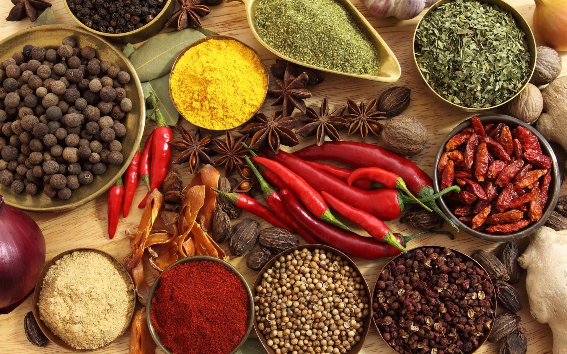 Spice 桌布 壁紙 — 一個充滿活力的俯拍鏡頭，展示碗中及散落在木質表面上的各式香料和香草。