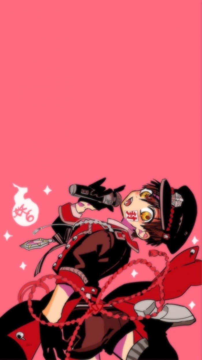花子君 桌布 壁紙 — 一個充滿活力的動漫角色，身穿紅黑服飾，帶有鏈條和帽子，在純粉紅色背景前手持槍支。