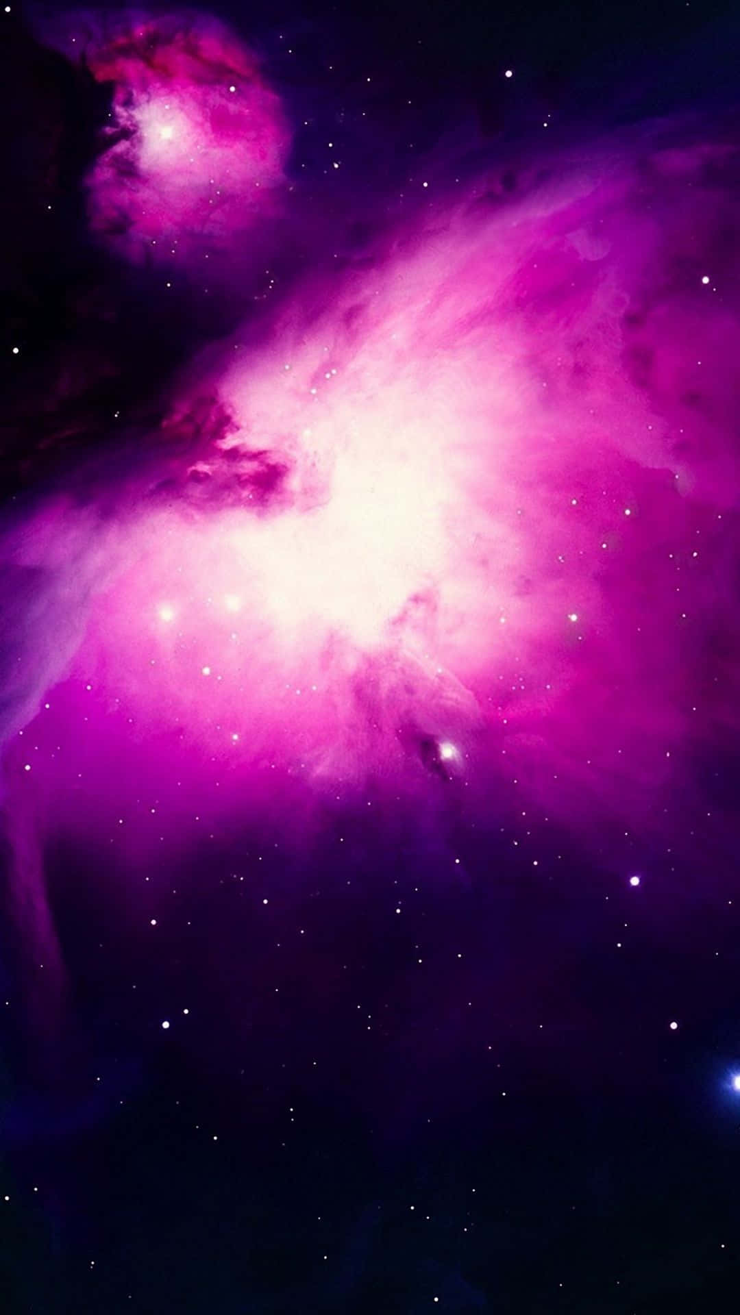 Pink Galaxy 桌布 壁紙 — 一個充滿活力的宇宙星雲，在佈滿星辰的黑暗虛空中散發著耀眼的粉紅色和紫色色調。