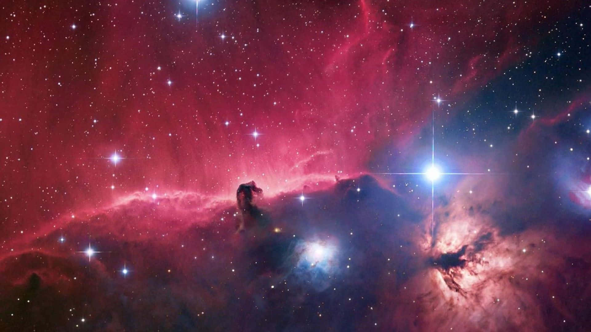 Universe 桌布 壁紙 — 一個充滿活力的宇宙星雲，在黑暗的虛空中散發著紅色和藍色的氣體雲，點綴著燦爛的星星。
