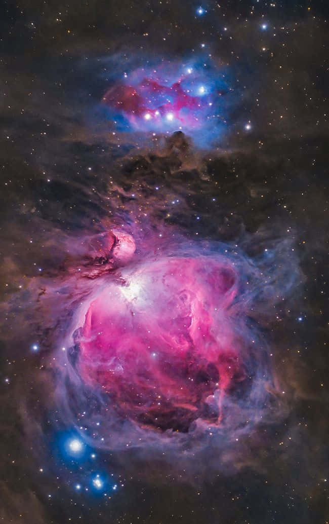 Interstellar Cloud 桌布 壁紙 — 一個充滿活力的宇宙星雲，有旋轉的粉紅色、紫色和藍色氣體雲，由明亮的星星在黑暗的星場中照亮。