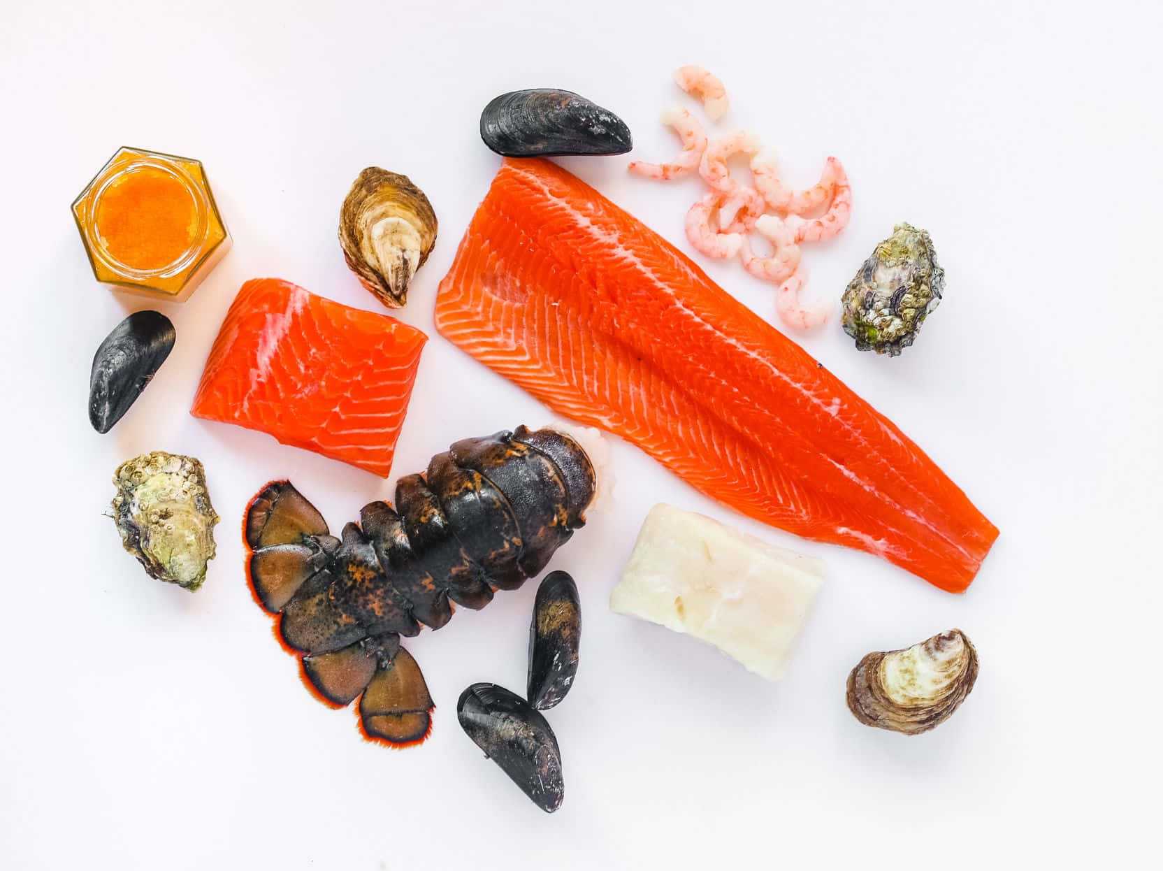 Seafood 桌布 壁紙 — 一個充滿活力的平鋪擺拍，包括三文魚柳、龍蝦尾、蝦、青口和生蠔，整齊排列在潔白的表面上。