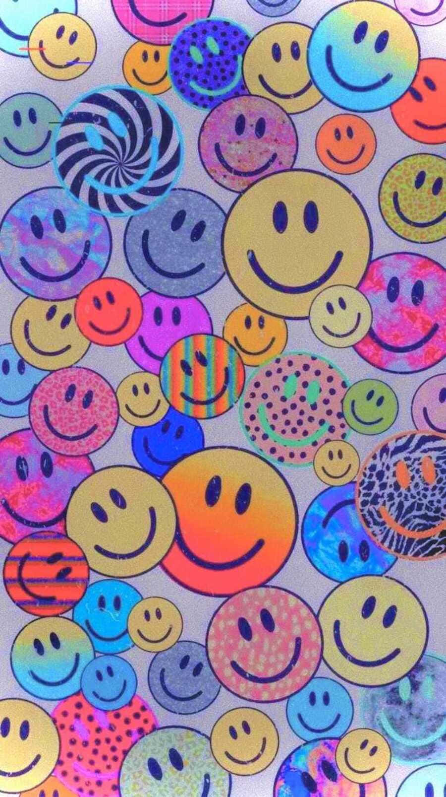 Aesthetic Smiley Face 桌布 壁紙 — 一個充滿活力的拼貼畫，包含色彩繽紛的笑臉，帶有迷幻圖案和全息光澤，背景為銀色。