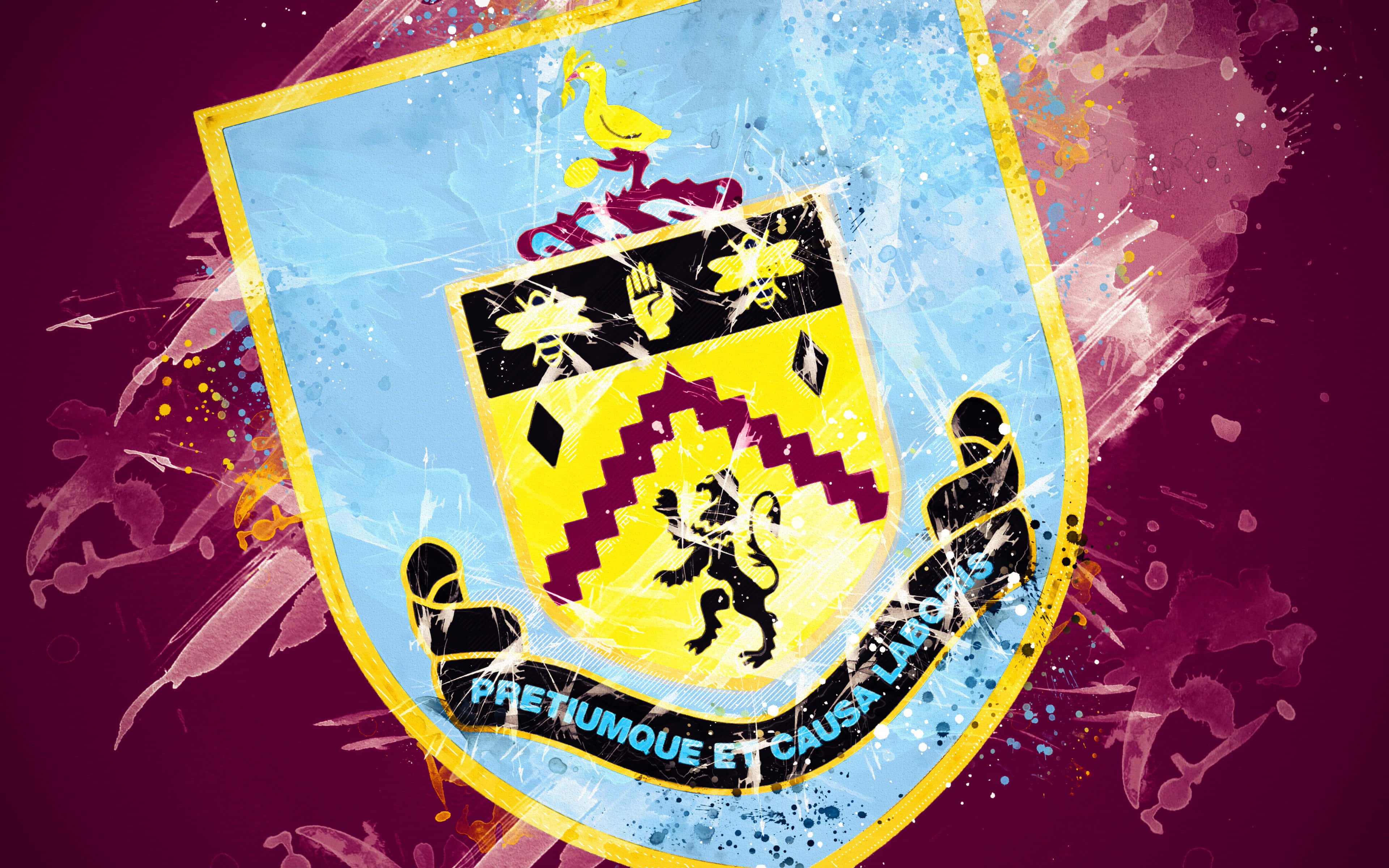 Burnley Fc 桌布 壁紙 — 一個充滿活力的數位藝術徽章，以黑色獅子和格言為特色，背景為栗色，帶有色彩繽紛的油漆飛濺。