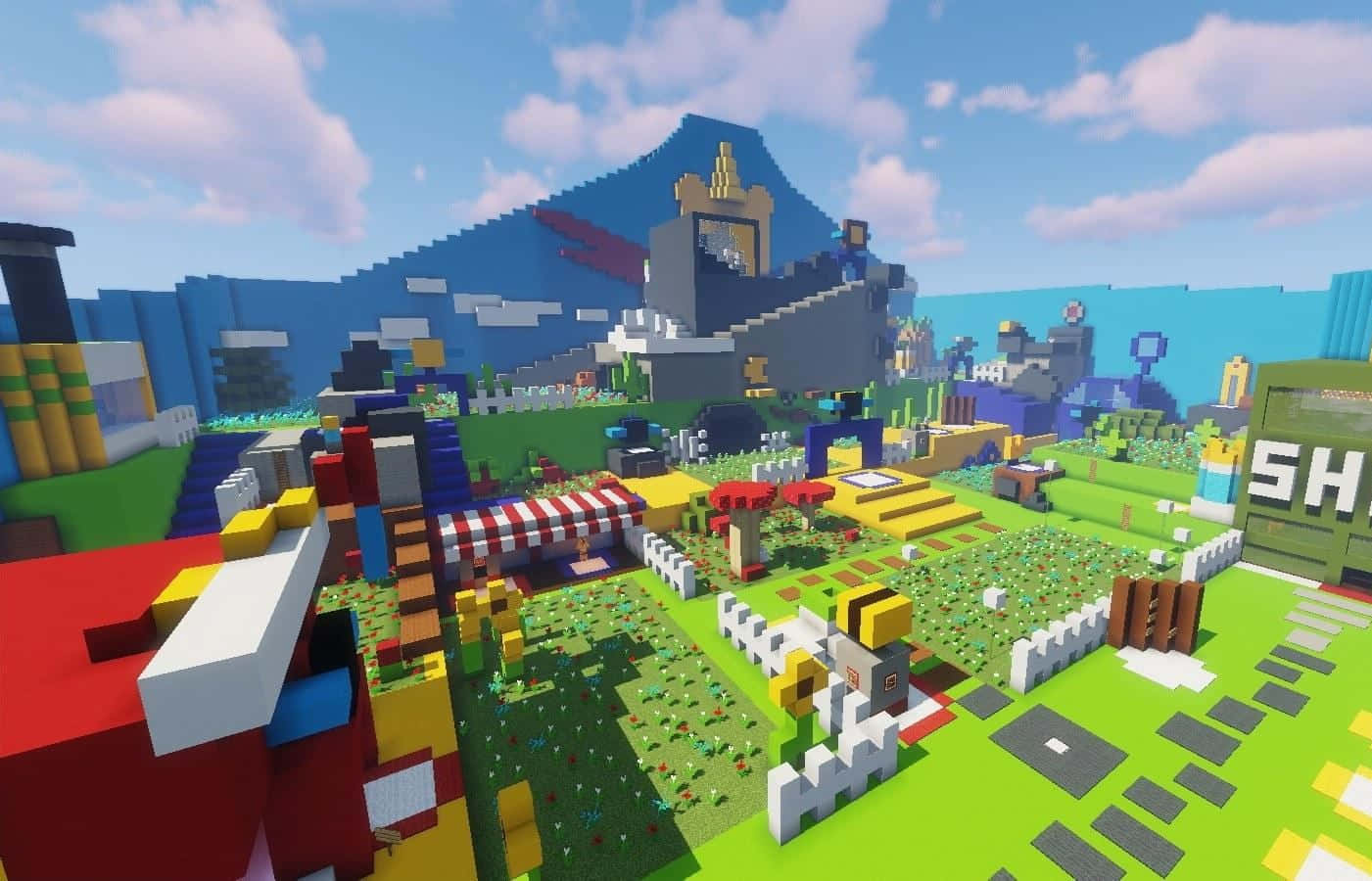 Minecraft Map 桌布 壁紙 — 一個充滿活力的方塊狀Minecraft村莊，有色彩繽紛的房屋、花園和一座藍色山上的城堡，在晴朗的天空下。