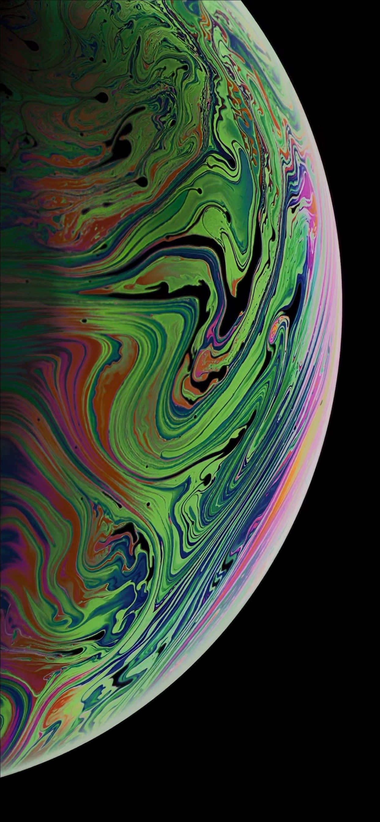 可愛 iPhone 壁紙 桌布 壁紙 — 一個充滿活力的旋轉肥皂泡，在黑色背景上呈現出虹彩般的綠色、橙色和紫色色調。