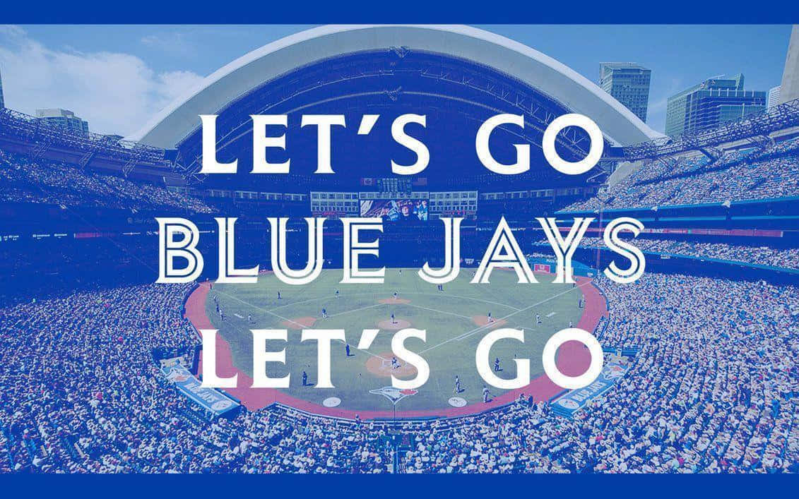 Blue Jays. 桌布 壁紙 — 一個充滿活力的棒球場，擠滿了球迷，藍天下有粗體白色文字為藍鳥隊加油。