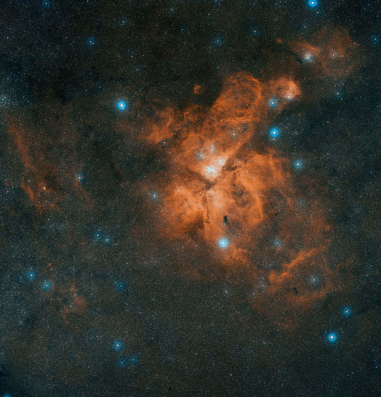 Carina Nebula 桌布 壁紙 — 一個充滿活力的橙色星雲在深空黑色背景中，在一片發光的藍色星群中旋轉。