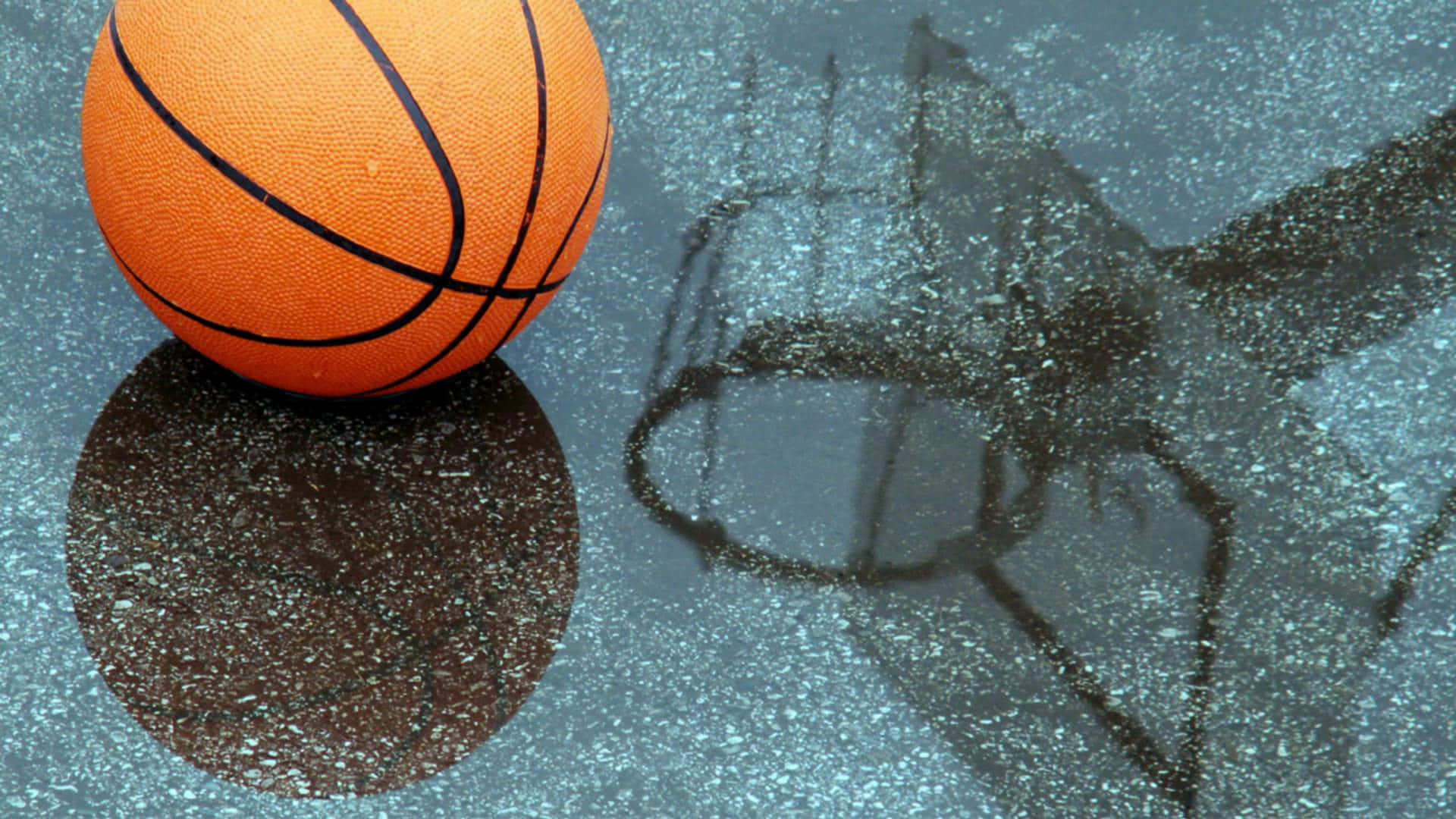 Cool Basketball 桌布 壁紙 — 一個充滿活力的橙色籃球放在潮濕的球場上，球場反射出它的影像和一個褪色的籃框輪廓。