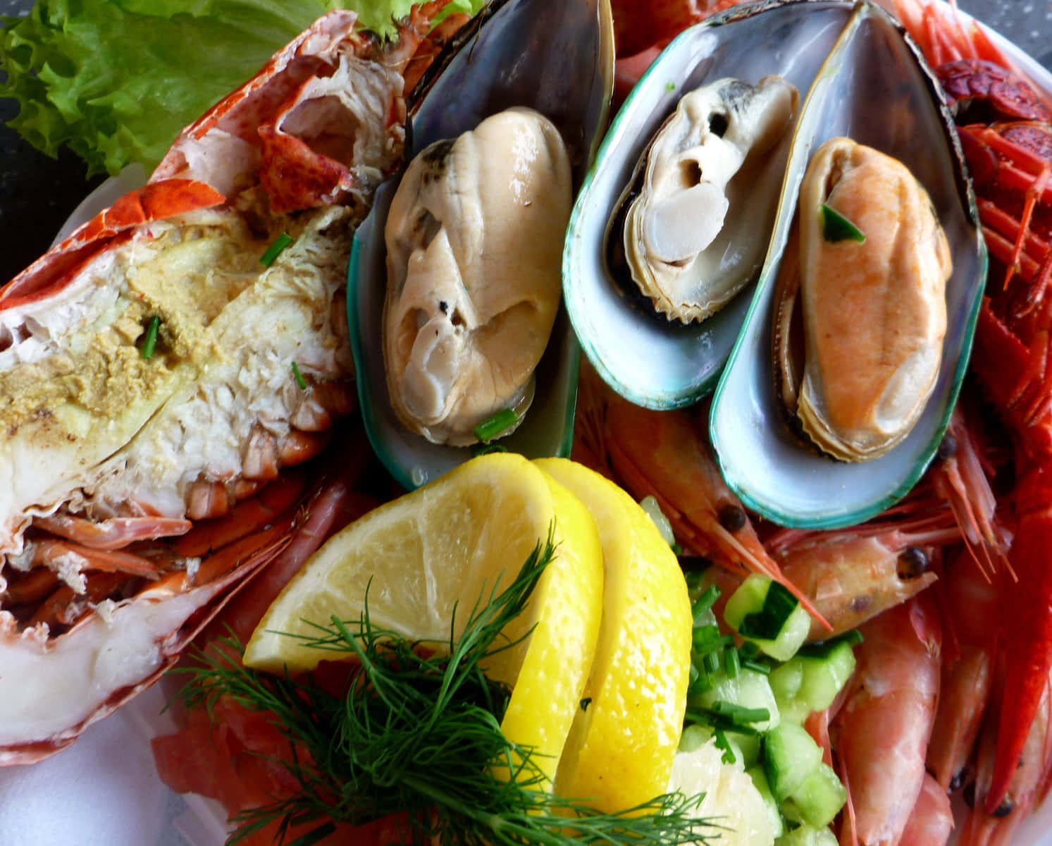 Seafood 桌布 壁紙 — 一個充滿活力的海鮮拼盤，包括龍蝦尾、青口、蝦、檸檬角和新鮮香草。